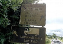 Dirty road sign at California Cross barely readable