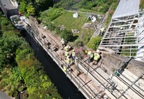 Builders working hard to mend wall and re-open road 
