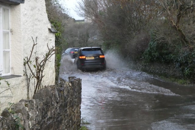 Drivers passing through the flooded road