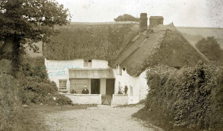 Home Park thatched house 1890.
Two people leaning on garden wall.