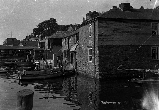 Clifton Place, Salcombe. Shows waterfront houses and small boats tied up to landings