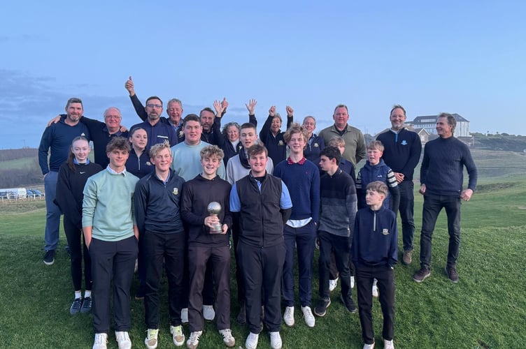 Photo of all the juniors and adults who played in the match of juniors v the club. William Hoskin in the front holds the Trophy