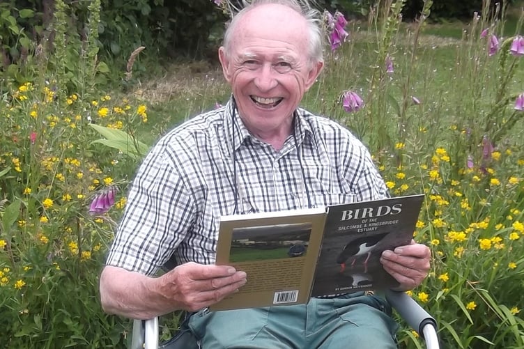 Gordon reading his book in his garden by Rachael Quick