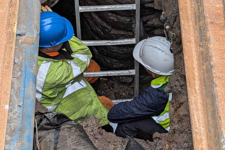 Kingsbridge Community College student with an engineer down a hole at the culvert site.